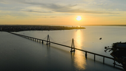Aerial view of the International Bridge at sunset with Posadas in the distance and golden light over the Paraná River.