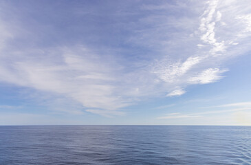 Obraz premium Serene Sky Reflected Over the Pacific Ocean Under a Light Cloudscape