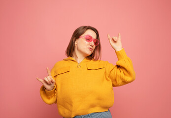 Pretty plump woman wearing yellow sweater happy ecstatic celebrating being a winner over pink...