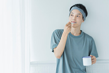朝の洗面台で歯を磨く若い男性
