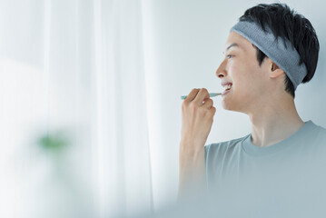 朝の洗面台で歯を磨く若い男性