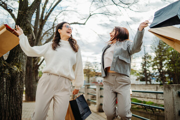 Naklejka premium Two female friends or sisters going home after shopping with shopping bags