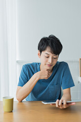 Naklejka premium 休日にタブレット端末で動画を見る若い男性