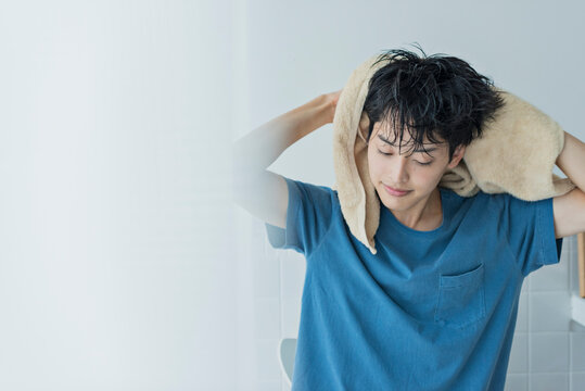 風呂上がりにタオルで髪を乾かす若い男性