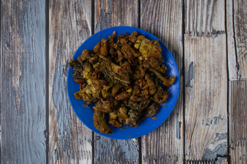 A traditional fried chicken skin dish, seasoned and served on a bright blue plate.