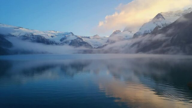 beautiful cold mountain lake with snow-covered peaks reflecting in water, peaceful and clean nature view in early morning light