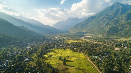 Fototapeta premium Breathtaking Aerial View of Lush Green Valley Surrounded by Majestic Mountains and Serene River Under a Beautiful Sky During Daylight Hours
