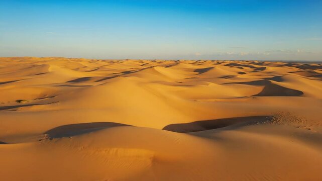 beautiful golden desert with high dunes under warm sunlight, natural patterns and shadows creating a calm and scenic sandy landscape