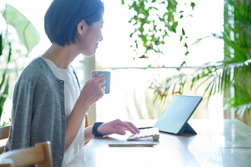 仕事中にマグカップを持って休憩する女性