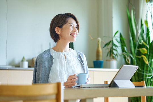 仕事中にマグカップを持って休憩する女性