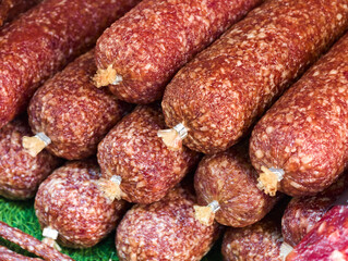 Savory selection of artisanal sausages displayed at a bustling market in the heart of the city during a sunny afternoon