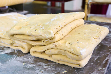 Layers of cracker dough resting on a floured surface in a cozy kitchen, ready to be shaped for delicious baking adventures ahead