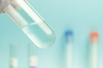 Scientist with chemical reaction in chemistry laboratory. close up making research in lab in blue background , water in test tube and blank space for advertising. front view science background