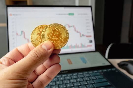 Hand holding golden coin crypto currency stock trade graph background new invest market. the concept of the fall of the cryptocurrency market