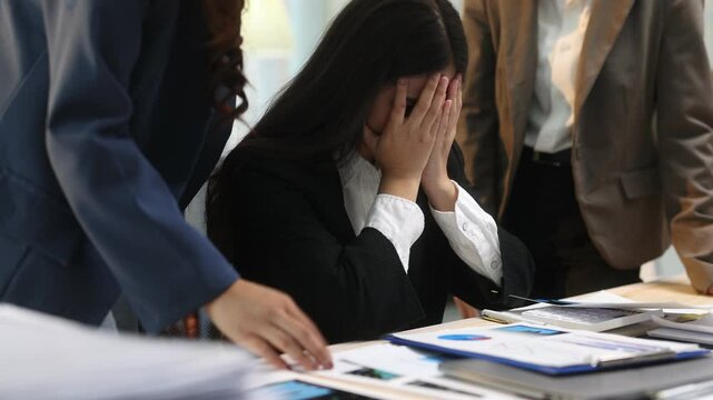 Businesswoman and supervisor blaming their stressed colleague. Women are stressed due to excessive workload.