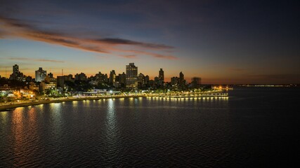 Evening cityscape of Posadas, Argentina, with waterfront lights reflecting on the Paraná River...
