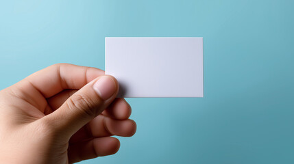 Fototapeta premium Hand Holding Blank White Card Against Bright Blue Background 