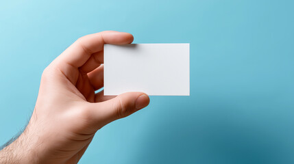 Fototapeta premium Hand Holding Blank White Card Against Bright Blue Background 