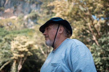 Older trekking adventure carries backpacks poles enjoying nature expression looks into the distance observing and possibly guide trekking and trail ecotourism adventure concept.