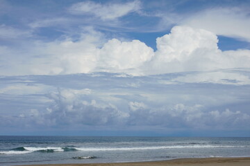 Coastal image showcasing the sea, a sandy beach, and a vibrant cloud-filled sky for marine-related ideas