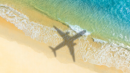 Aerial view of shadow passenger plane silhouette and sandy beach blue sea with waves at sea beach summer vacation sea travel concept	