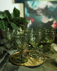 Elegant green set of glasses for drinks on a golden tray