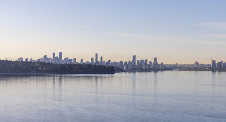 Fototapeta premium Panoramic View of Vancouver Skyline in BC with Water Reflecting Morning Light