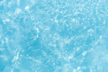 Blue water with ripples on the surface. Defocus blurred transparent blue colored clear calm water surface texture with splashes and bubbles. Water waves with shining pattern texture background.