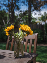 Sunflower bouquet on wood table outside in summer 