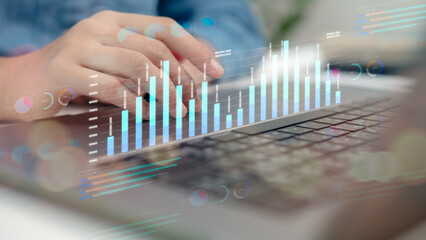 Close-up of hands on laptop keyboard with digital analytics dashboard, bar chart, and data visualization, representing financial analysis, business intelligence, and KPI tracking.