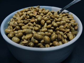 Fried soybeans in a bowl with a spoon. delicious and savory.