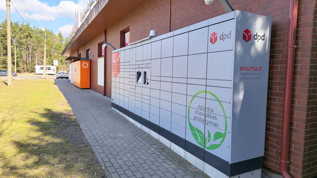 Vilnius Lithuania - 03.30.2025 Modern outdoor parcel lockers for self-service package delivery near a building on a sunny day