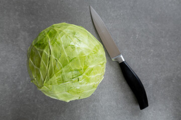 cabbage with knife on gray background