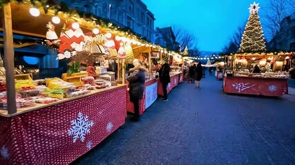 Smiling vendor at a festive outdoor Christmas market stall selling colorful sweets and shiny ornaments under glowing evening lights - Powered by Adobe