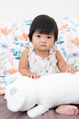One year old asian girl with plush toy in cozy home setting emotional portrait for family moments