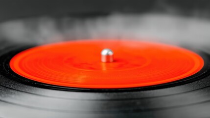 Close-up of an orange vinyl record on a turntable. Vintage music player with a spinning disc. Black and orange album release on a retro storage medium