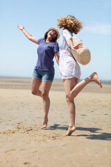 portrait of two female friends walking on the sea shore