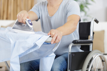 Fototapeta premium disabled man on wheelchair ironing clothing