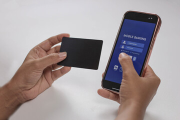 woman hand holding smart phone to access her mobile banking and holding her card