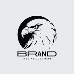 Black and white eagle logo design with company branding. Bold, powerful profile view of an eagle head against a circle with a modern text design for a company logo.