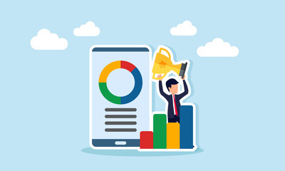 Businessman lifting trophy standing behind chart and next to smartphone displaying pie chart representing company success