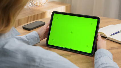 Woman sit desk use click digital tech tablet, green screen mock up. Hand swipe pad web site. Girl hold pad closeup press tap touch middle. Chroma key page. Cozy home background. Online app copy space