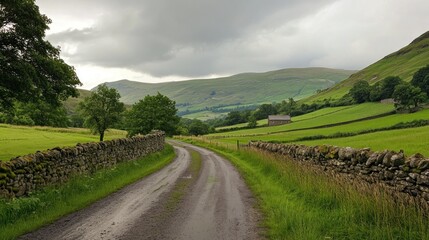 Fototapeta premium Picturesque countryside lane winds through the pastoral landscape of Cumbria
