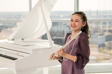 Young Girl Playing Flute by a Grand Piano © Cavan
