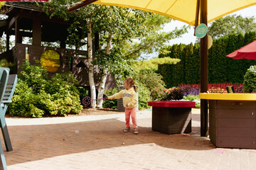 Young child using bubble wand and playing in garden