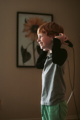 Young boy laughing while jumping rope indoors