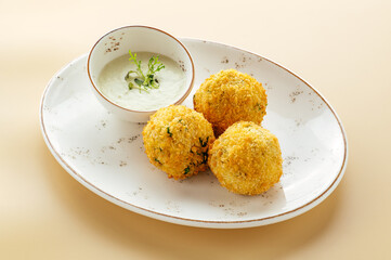 falafel with sauce and herbs on a plate