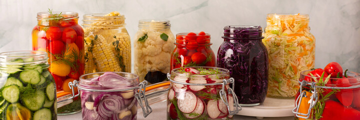 Fresh vegetables like cabbage, tomatoes, cucumbers and radishes, onions, corn, peppers and cauliflower, fermenting naturally to boost health and preserve nutrients, banner