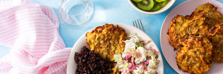 A balanced and nutritious breakfast with brown rice, baked white fish, fresh zucchini-carrot pancakes, a Chinese cabbage salad, and a sweet kiwi dessert, providing a perfect energy boost, banner