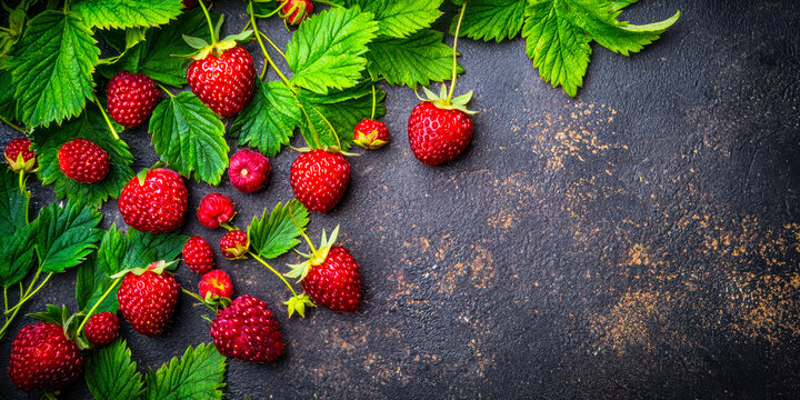 red berries of fresh raspberries on a black table